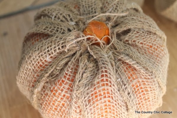 Make Your Own Burlap Pumpkin -- take a dollar store pumpkin and make it extra special with burlap! This burlap pumpkin is wrapped and now ready for the next step!