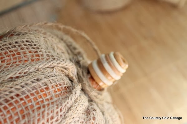 Make Your Own Burlap Pumpkin -- take a dollar store pumpkin and make it extra special with burlap! Create a new pumpkin stem using buttons--I used brown and white buttons