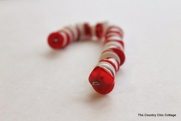 Button Candy Cane Christmas Ornaments -- handmade ornament tutorial that will have your tree full of button candy canes in no time. finishing white and red candy cane ornament