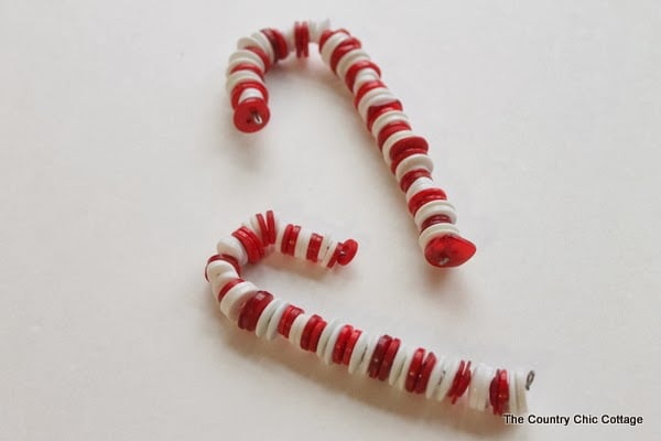 Button Candy Cane Christmas Ornaments -- handmade ornament tutorial that will have your tree full of button candy canes in no time. two white and red candy cane ornaments