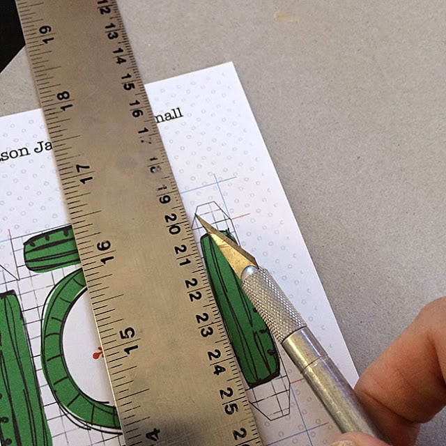 using a ruler and scoring tool to score lines before folding or cutting