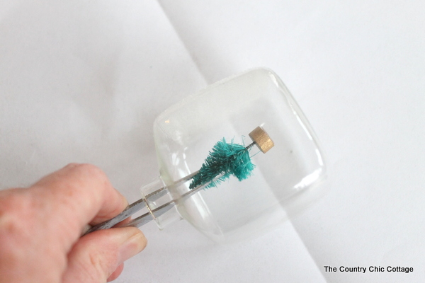 Kids Craft: Mini Snow Globe Ornaments -- click the picture to get the full instructions for making your own fun Christmas ornaments. adding glue and position mini tree to inside of ornaments