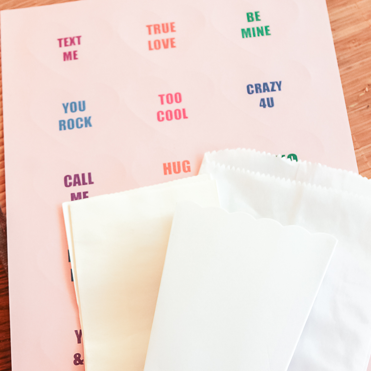 conversation heart stickers with white bags on a table