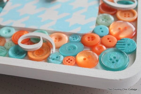 DIY Button Clock -- make your own button clock for a craft room or any room in your home. glueing numbers on top of the buttons