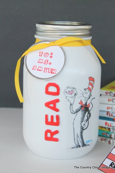 Dr. seuss gift in a jar next to stack of books and homemade bookmark.