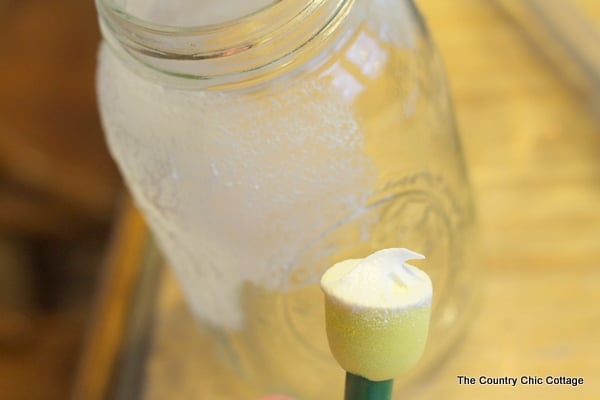 adding glitter snow to make winter-themed DIY Solar Mason Jar Lights 