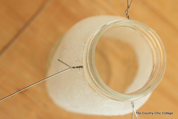 placing wire around the mouth of the mason jar to create a lantern handle