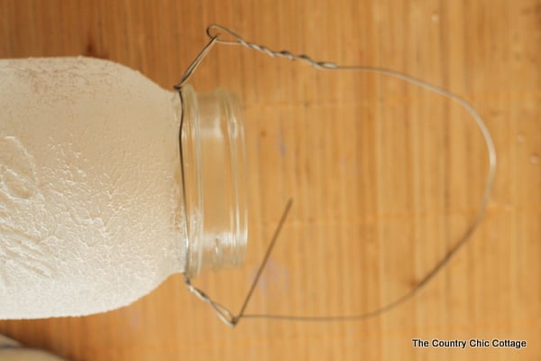 Solar Mason Jar Lights -- add tops to your mason jars and use solar power to light up the outdoors. adding the wire handle to this DIY lantern