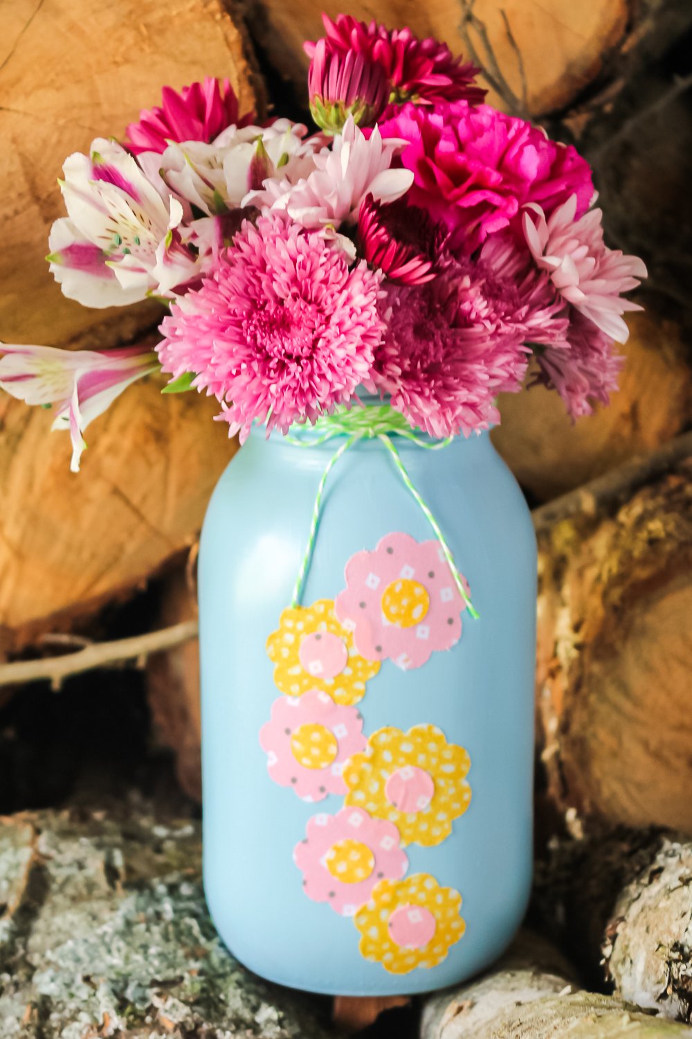 blue mason jar with pink and yellow fabric flowers on the front
