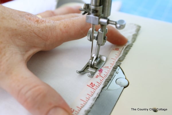 sewing the hem using the tape measure as a guide