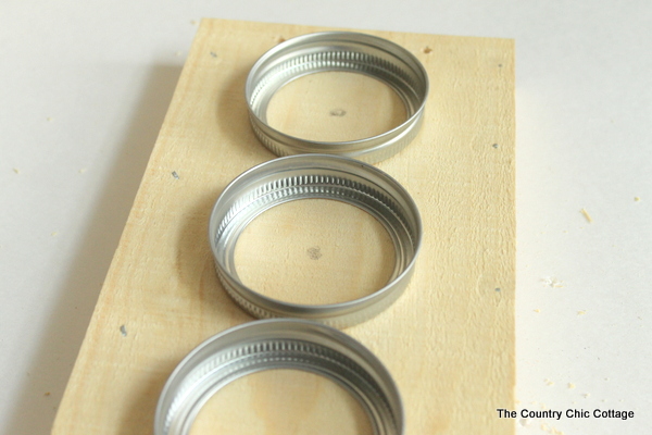 spacing out the mason jar bands to drill holes for the lights