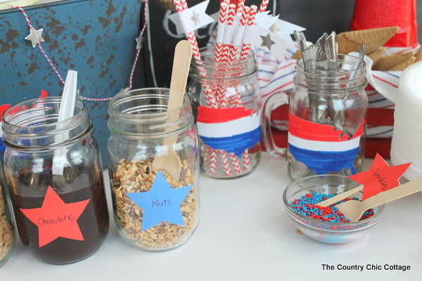 mason jars with ice cream toppings and utensils