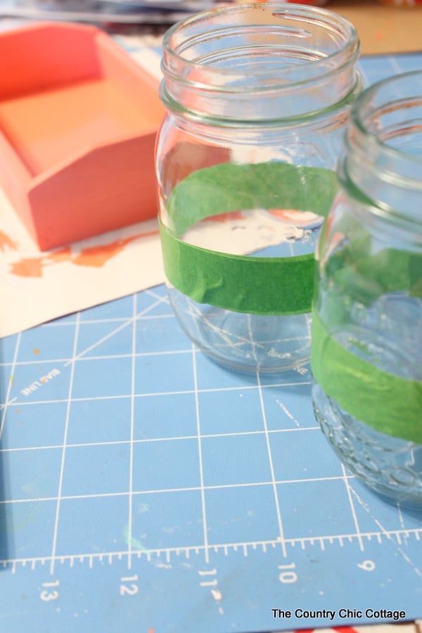 Two mason jars with painter's tape on them. 