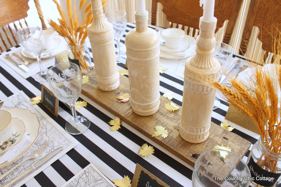 wine bottles with candles on a fall table