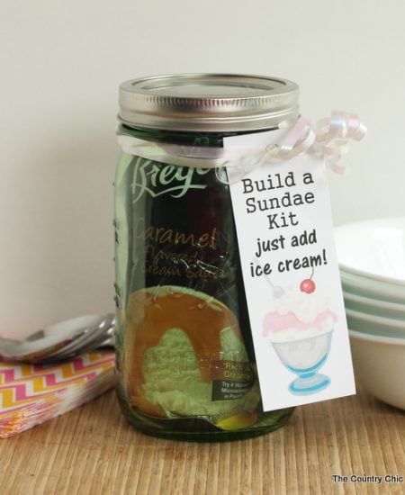 Build a Sundae Kit Gift in a Jar -- fill a mason jar with everything needed for a sundae but ice cream. Includes free printable tags!