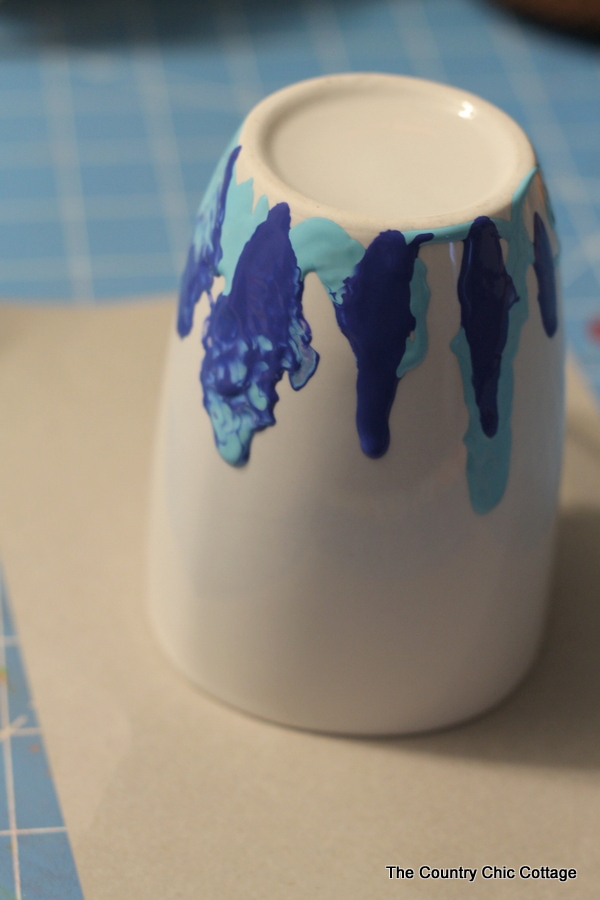 Creating a DIY marbling design on a white coffee mug. 