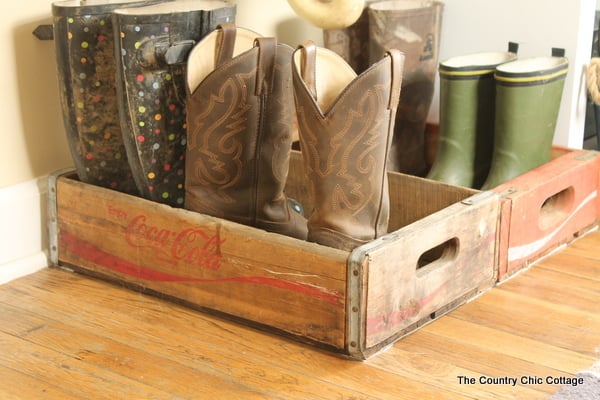 Farmhouse mudroom ideas, boots inside of a wood crate.