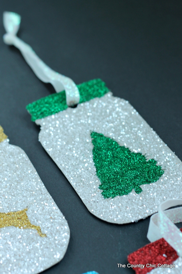 Make these glittered mason jar ornaments easily with a Cricut Explore. Click here to learn how!