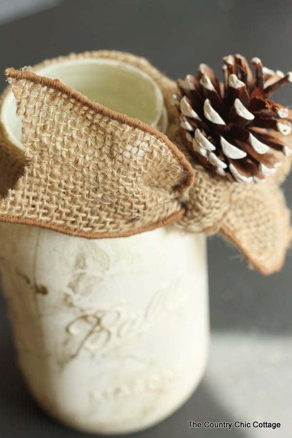 burlap ribbon and pine cone on gold marbled mason jar