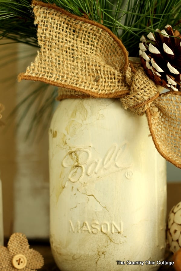 Gold Marbled Mason Jar displayed with greenery, burlap ribbon and pine cone