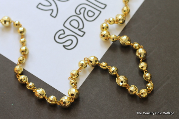 Make this gold ball garland plus print a free coloring page printable and never let anyone dull your sparkle!