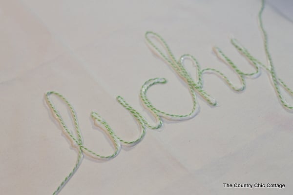 adding words to pillow canvas with twine