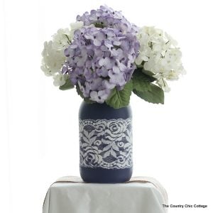 Lace Mason Jar Vase -- use two paint colors and lace as a mask to create this gorgeous painted vase for your wedding, home, or any party. Get the full step by step instructions here. Can you believe this is just paint? There is no actual lace on this jar!