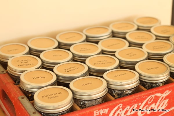 old coke crate with mason jars organizing screws, nails, and bolts