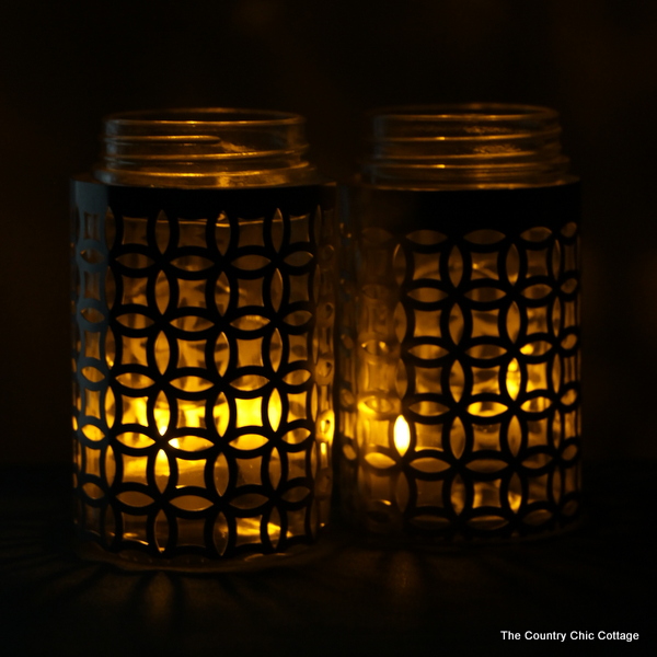 metal-wrapped jar candle holders lit up at night