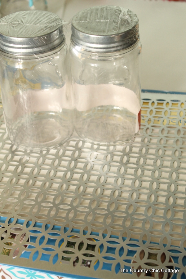 mason jars sitting on decorative metal sheet