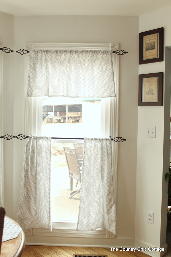 rustic iron curtain rods hanging high and low on windows and hanging curtains