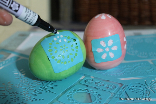 color in stencil on ceramic egg with white pen