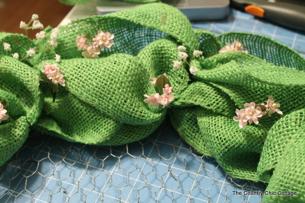 putting flowers on the Spring Burlap Wreath