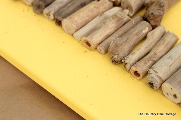 arranging driftwood pieces on canvas