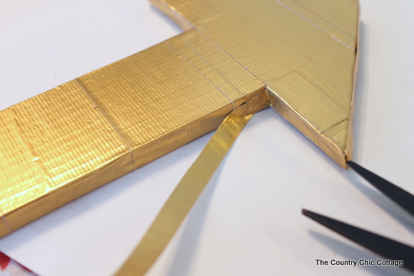 Metallic gold arrow made from cardboard boxes and Duck tape -- get the full instructions here!