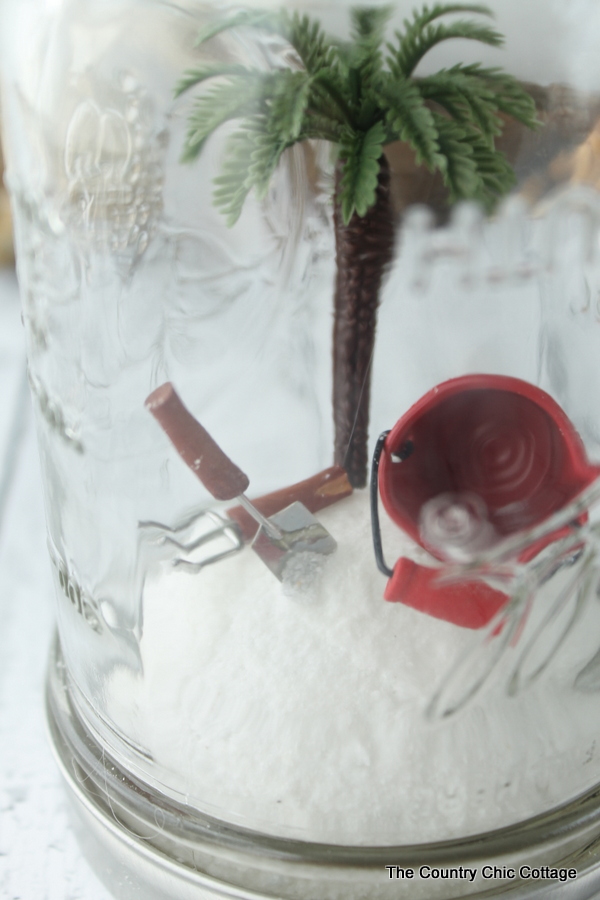 Close up on miniature palm tree, shovels, and buckets.