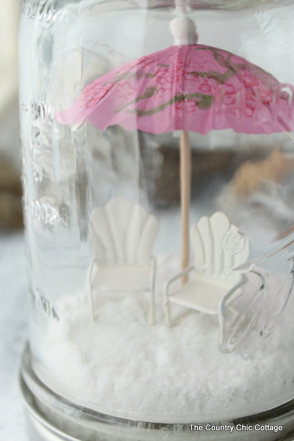 Close up angle of the mini umbrella and beach chairs in the mason jar.