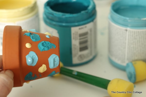 adding dots of paint to mini terra cotta pots