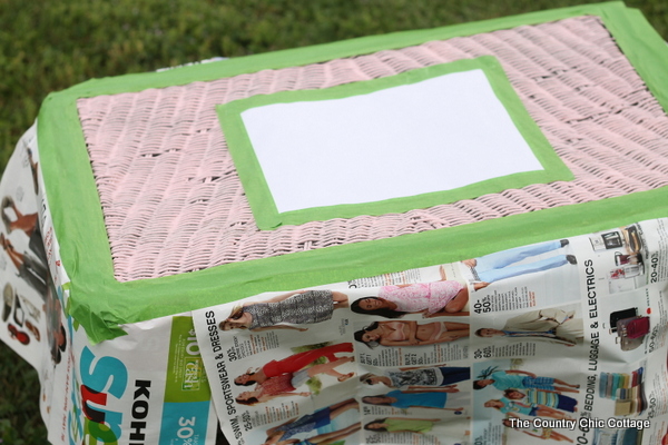 process image showing paper and painter's tape added to create a paint design on this table