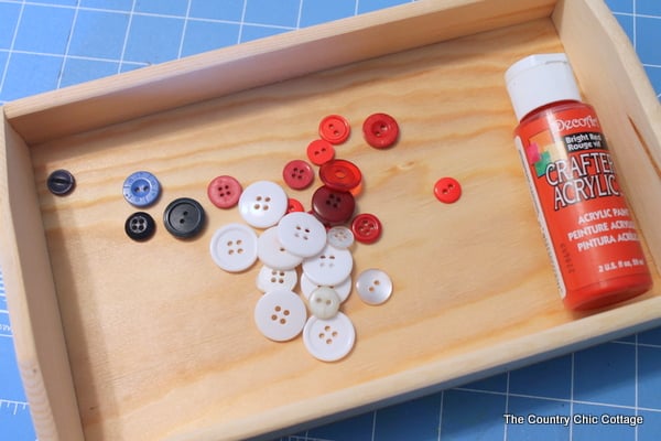 Red, white and blue buttons on a wood serving tray.