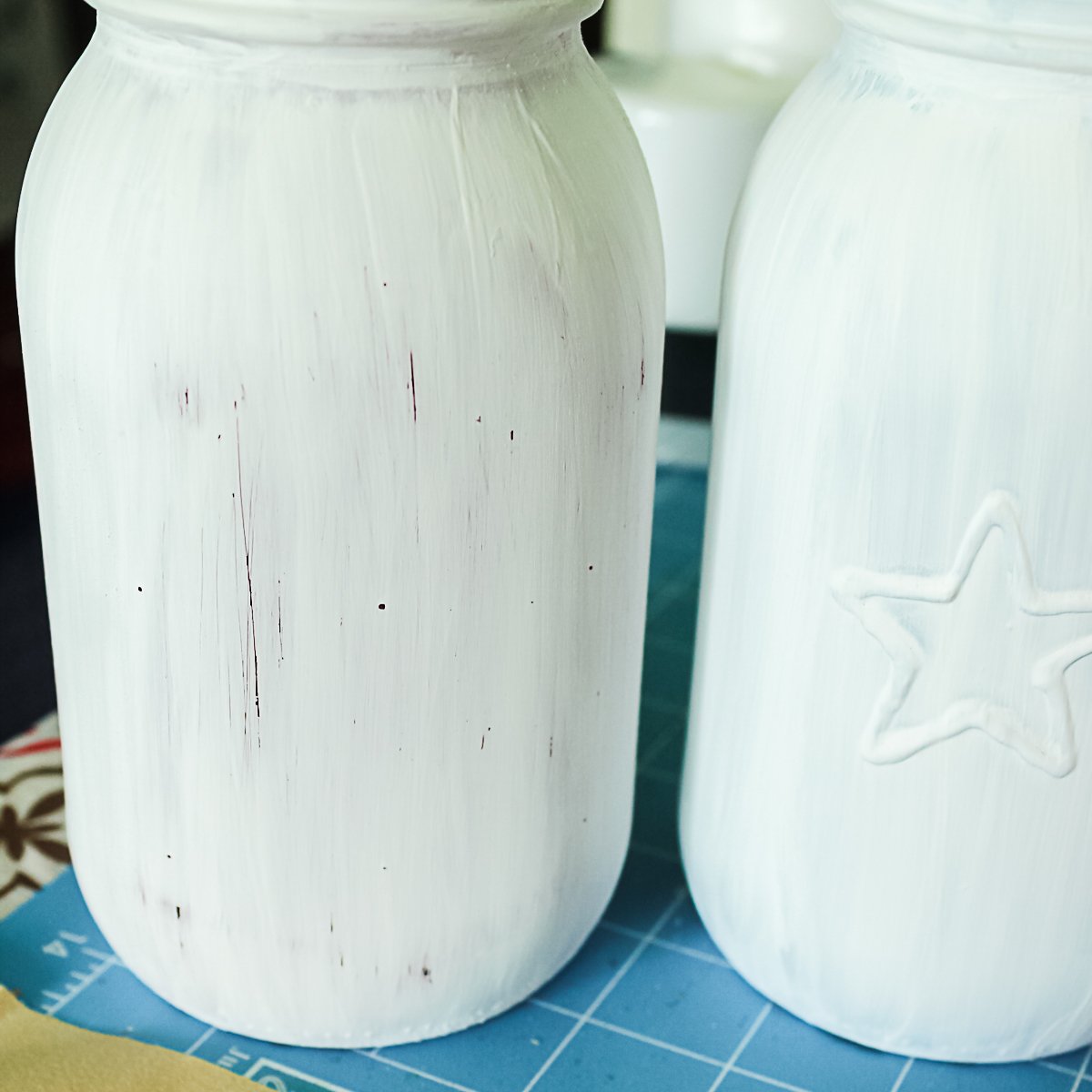 adding white paint to a mason jar