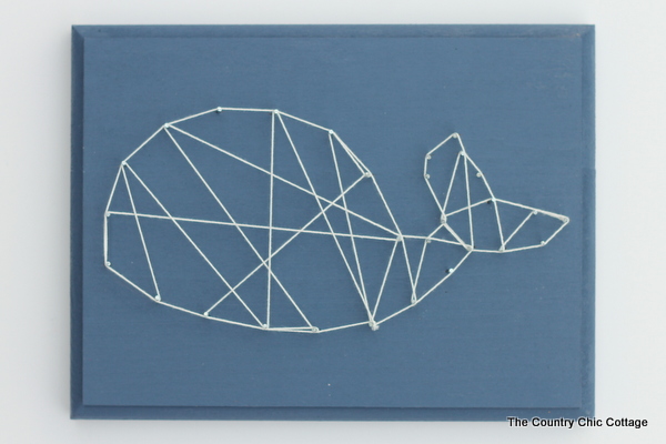 A geometric string art whale made with nails and baker's twine