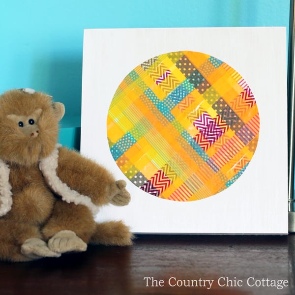 Washi tape wall art on canvas next to stuffed monkey