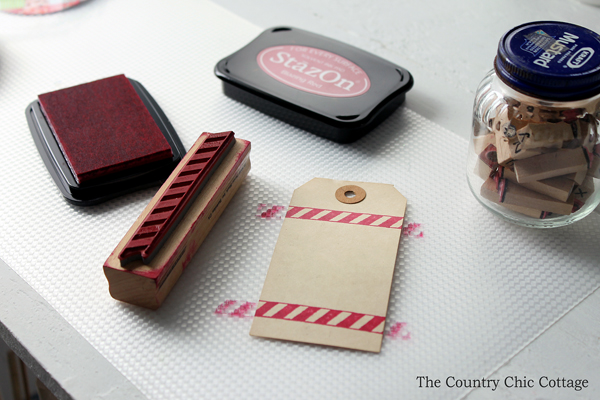 stamping a gift tag with red candy stripe stencil