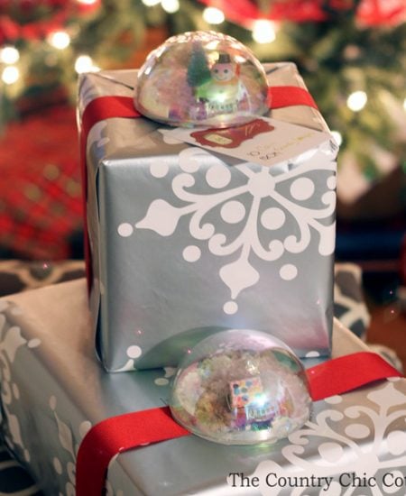 Make these snow globe present toppers for your Christmas gifts! A great addition to holiday presents in place of a traditional bow!
