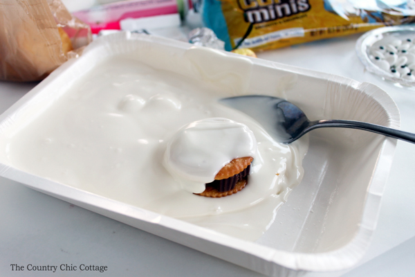 coating cookie sandwiches in white melted candy