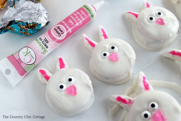 adding the bunny nose to easter bunny cookies with pink icing