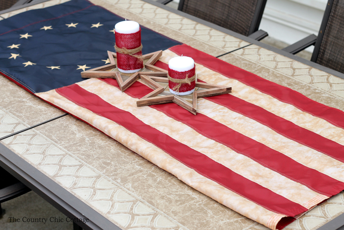 tea-stained 4th of july flag on table with wooden stars and candles
