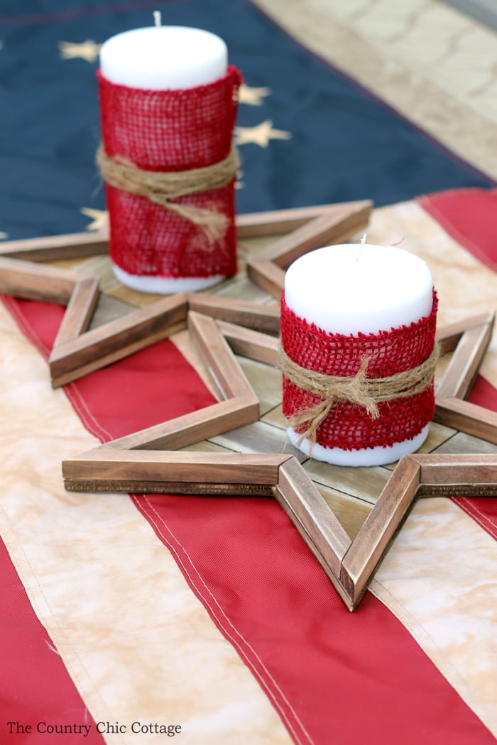 candles wrapped in red burlap sitting on top of burlap stars 