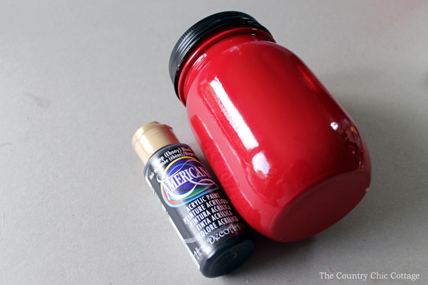 mason jar painted red with bottle of black paint